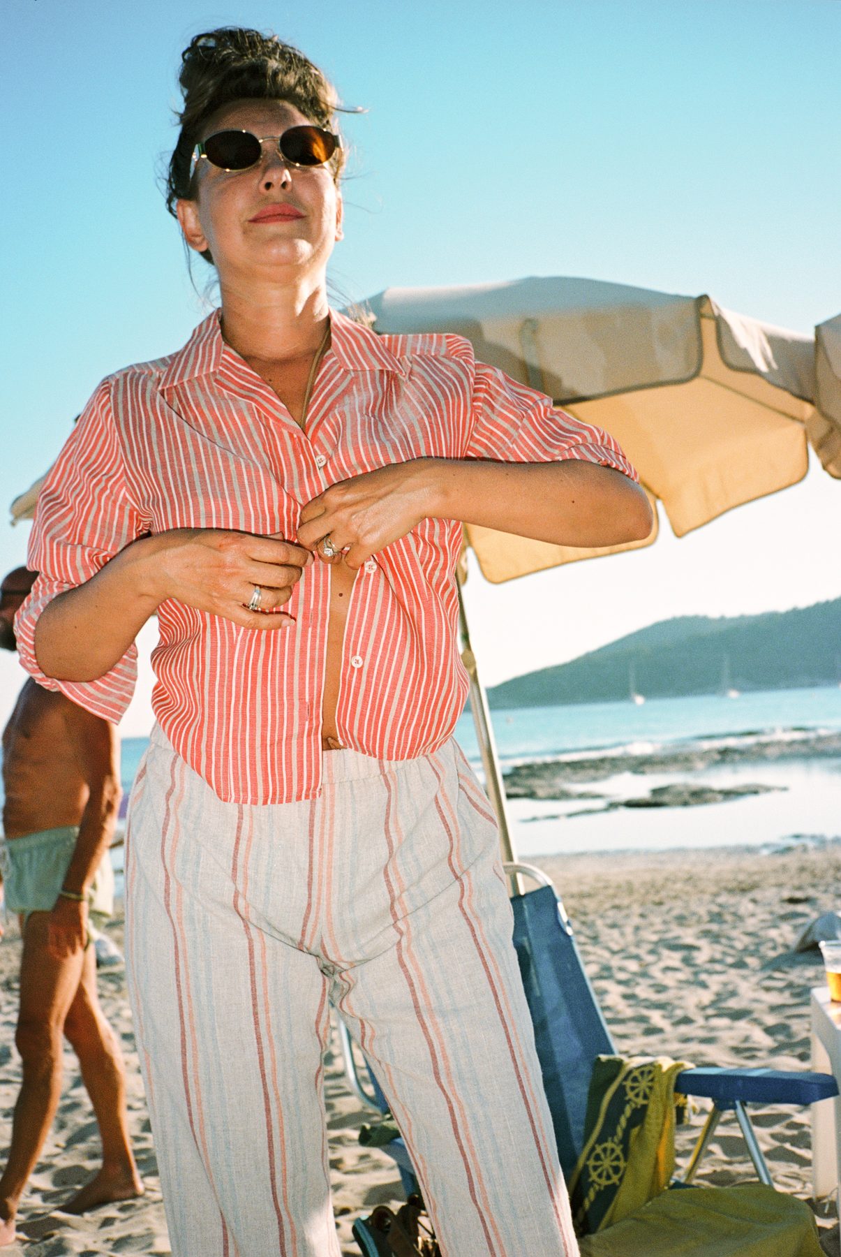 Scan 18 — coral stripe shirt and cream stripe trousers under a parasol